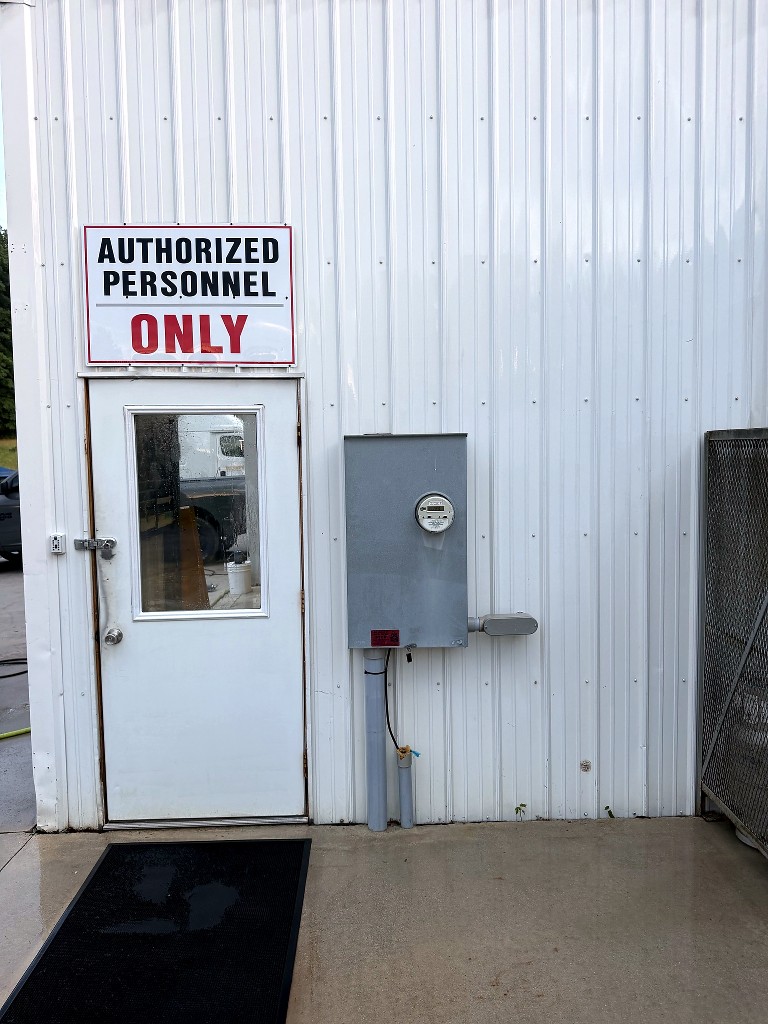 Building entrance after pressure washing — clean white door and siding