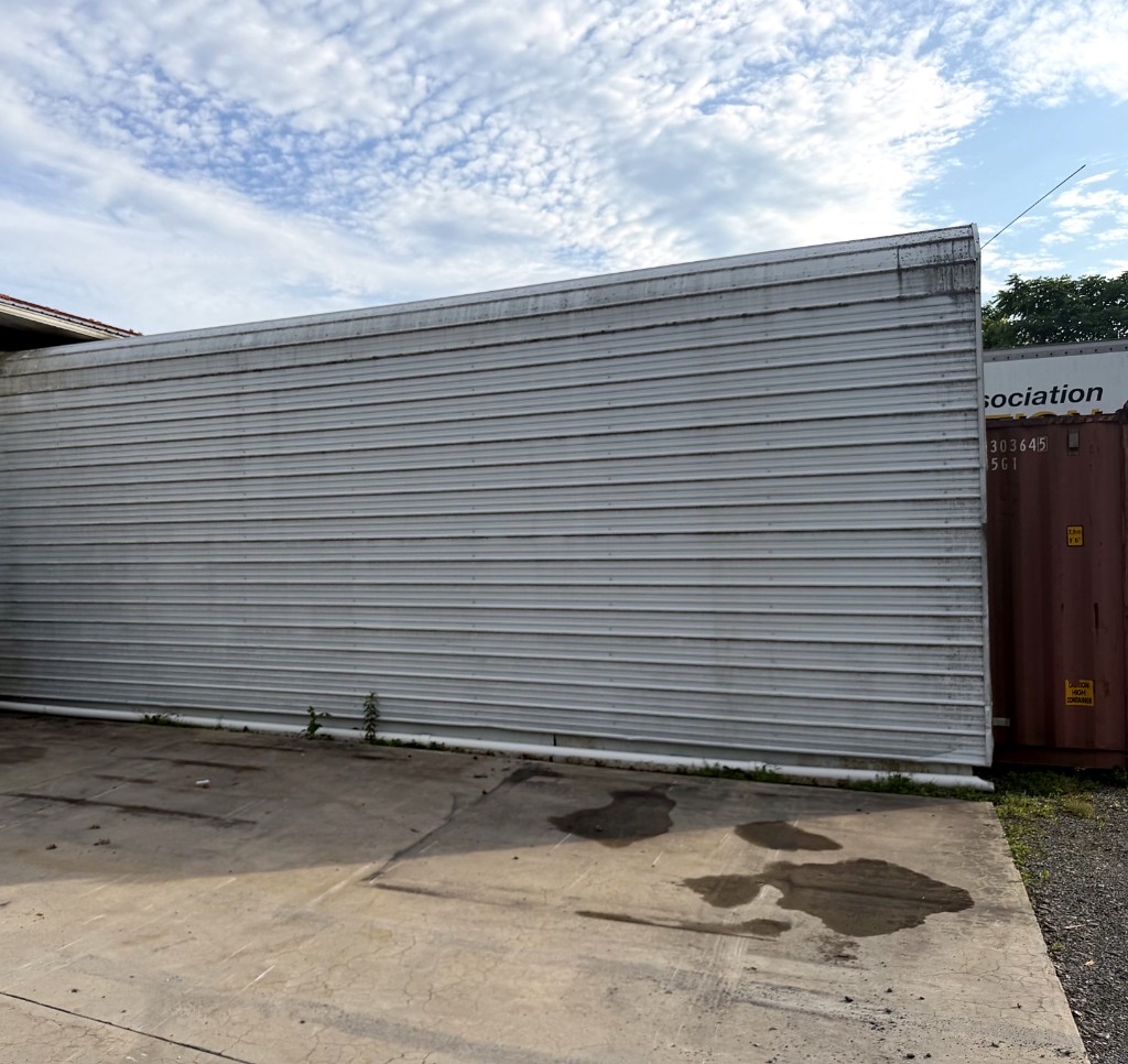 Commercial metal wall before pressure washing — heavy grime and mildew staining